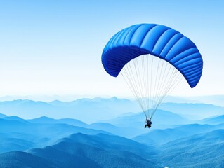 Blue Paraglider High Above Misty Mountains