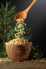 Pine nuts is poured in a wooden bowl.