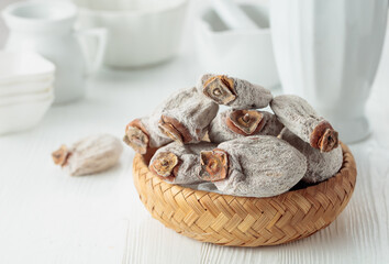Dried persimmons on a white wooden table.