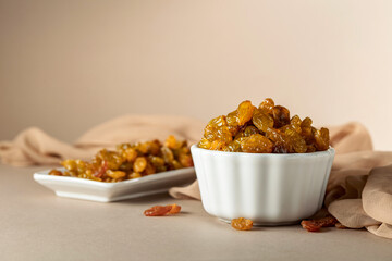 Yellow sultana raisins in a white bowl.