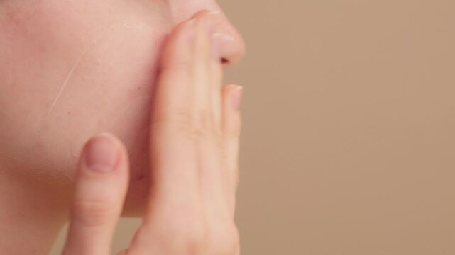 Morning beauty routine. Young woman applies nourishing face cream as part of her skincare and makeup prep routine. Hydrates and smooths the skin for a flawless and radiant makeup application.