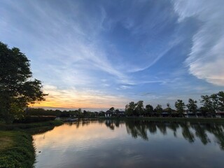 Fototapeta premium Still Lake Reflecting Twilight Sky and Trees in Bangkok