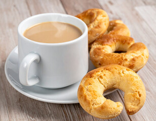 A steaming cup of caf� con leche with medialunas (crescent-shaped pastries), representing a typical Argentine breakfast or snack.