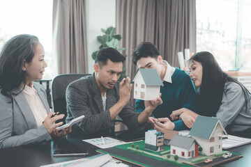 Business team signing investment agreement for residential real estate. Group of professionals in suits meeting in office with financial agreement documents on table.