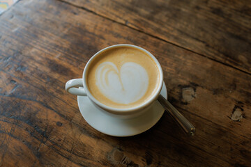 A steaming cup of coffee adorned with a heart-shaped pour, lovingly prepared and ready to delight the customer.