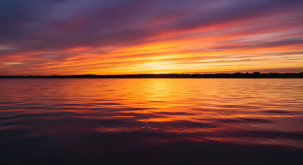 Fototapeta premium Spectacular Ocean Sunset With Fiery Colors And Soft Waves Reflecting Horizon