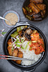 Korean vegan bowl with rice, tofu, eggplant and pepper, kimchi.