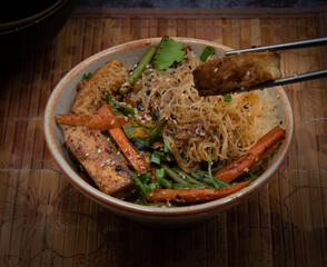 Vegan tofu and vegetables  stir fry  and bean thread noodles in serving bowl