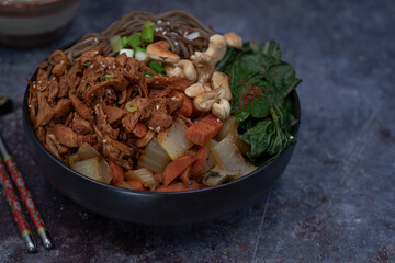 Vegan Korean noodle and jackfruit bowl with carrot and bok choy, bibimbap