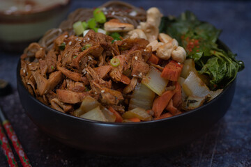 Vegan Korean noodle and jackfruit bowl with carrot and bok choy, bibimbap