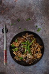 Korean vegan braised eggplant gaji namul  served in dark bowl