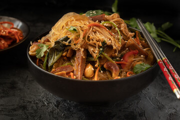 Vegan Korean Japchae in black bowl against black backround