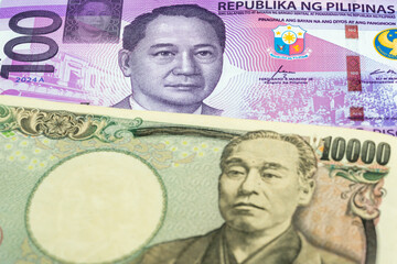 100 Philippine peso and 10000 Japanese yen banknotes. International trade concept