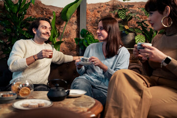 Young friends flirting and enjoying tea together in cozy vintage cafe, authentic connection