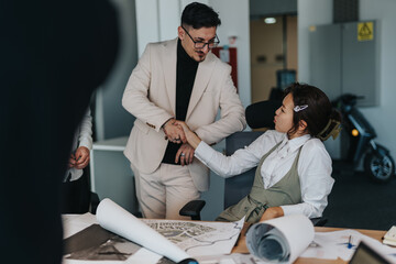 A diverse team of business people engaged in brainstorming and analyzing documents in a modern office setting. Collaboration and teamwork are evident as they discuss and work on a project.