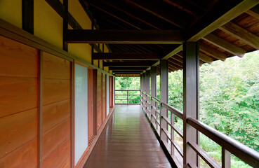 A diminishing perspective of a veranda in a traditional Japanese house with wooden floors, eaves,...