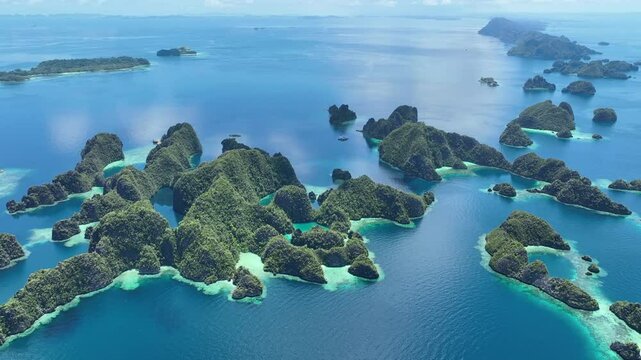 A set of scenic limestone islands rise from the ocean in Misool, Raja Ampat, Indonesia. This area is known as the heart of marine biodiversity and is a popular destination for diving and snorkeling.