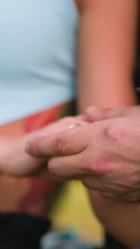 Loving man and woman join hands and lady strokes leg thigh of boyfriend sitting together at romantic date on spring day close view slow motion