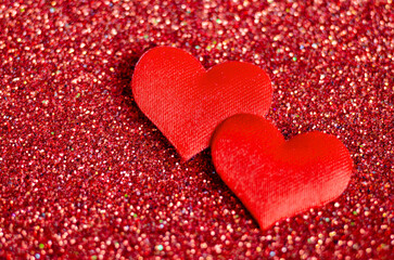 Top view of tiny red hearts on sparkle red background with customizable space for text or wishes