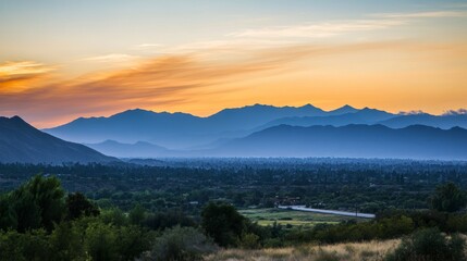 Scenic sunset view over valley and distant mountain range.