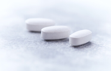Amino acids tablets on wooden background. Soft focus. Close up	