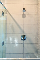 A modern walk in shower with a glass door