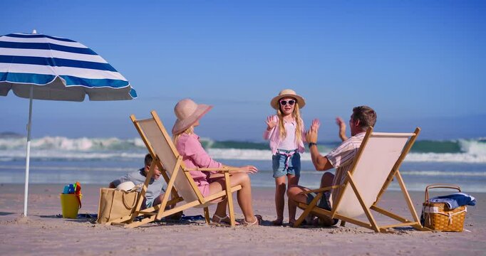 Family, playful and children on beach outdoor with high five games, tropical island and bonding together. Parents, kids and relaxing with fun for vacation travel, ocean activity and love of picnic