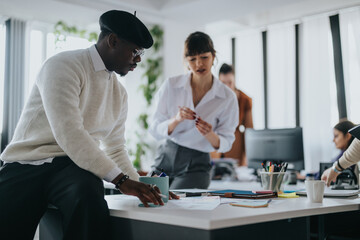 Group of diverse professionals working together in an office environment, sharing ideas and focusing on a common goal. The atmosphere is dynamic and collaborative, emphasizing teamwork and creativity.