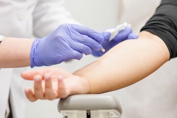 Medical professional performing an allergy skin test by pricking the patient forearm with a small lancet