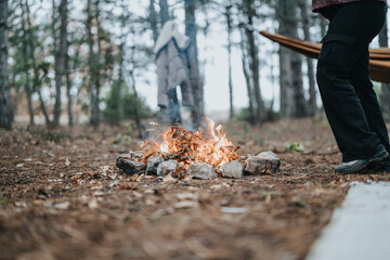 Enjoying a cozy winter picnic in the forest. Scene depicts a campfire amidst trees, a relaxing and soothing setting.