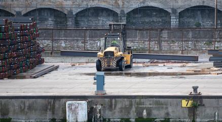 forklift handling steel beams in the port