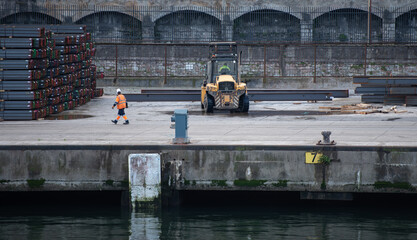 forklift handling steel beams in the port