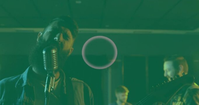 Singer and bandmates rehearsing under green light, with animated sound waves for music production