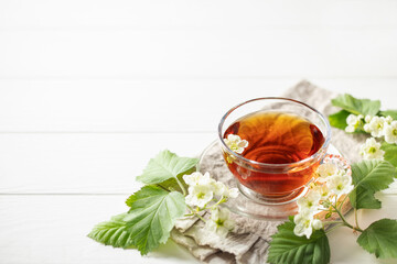 Alternative herbal drink. Hawthorn spring floral tea with spring blooming branches  on wooden...
