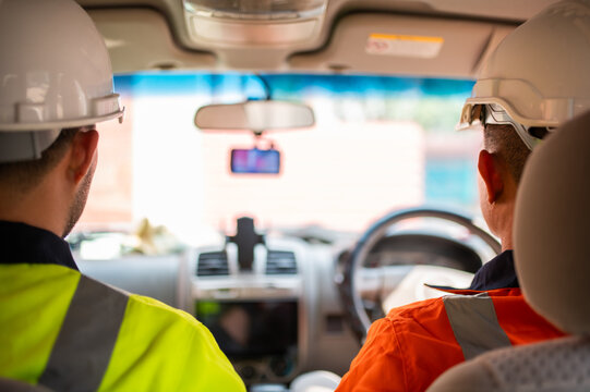 Two engineers are sitting in a pickup truck, ready to go out to inspect a construction project