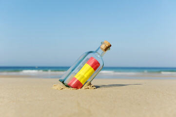 Spanish flag inside a bottle thrown into the sea with a homeland message. European flags, European Union flags. Sun and beach vacations on the coast of Spain.