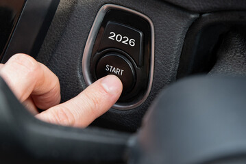 2026 START written on the car button. A finger pressing a New Year 2026 start button. New Year change, challenge and resolution concept