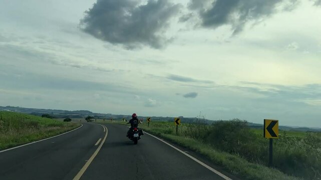 Mulher motociclista na auto via estrada com asfalto 