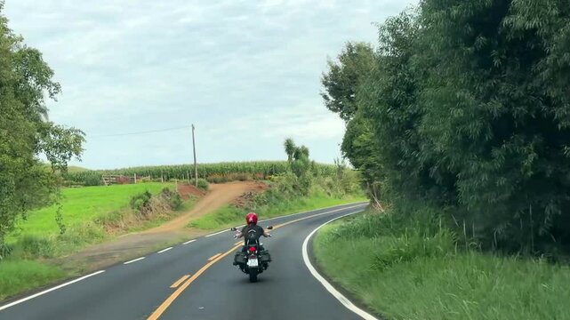 Mulher motociclista na auto via estrada com asfalto 