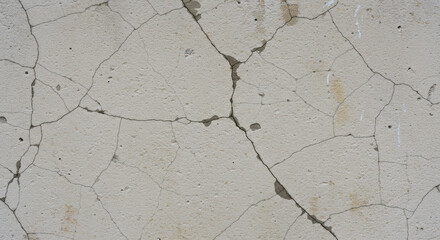 Obraz premium Detailed close-up of a weathered concrete surface with prominent cracks and a grainy texture, showcasing aging and structural deterioration.