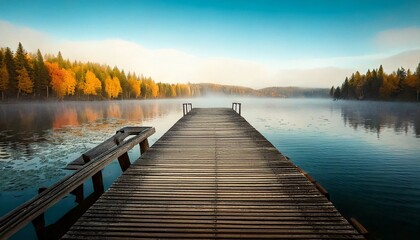 Fototapeta premium Muelle de madera solitario que se extiende hacia el lago brumoso durante el otoño, fotografía hiperrealista,