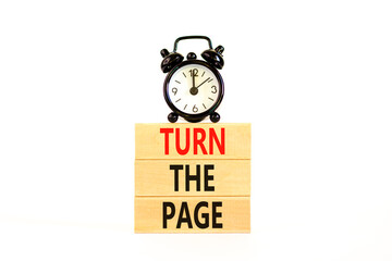 Turn the page symbol. Concept words Turn the page on beautiful wooden block. Black alarm clock....