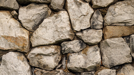Dirty, old and grunge look rock wall. Stacked rough stone textured background.