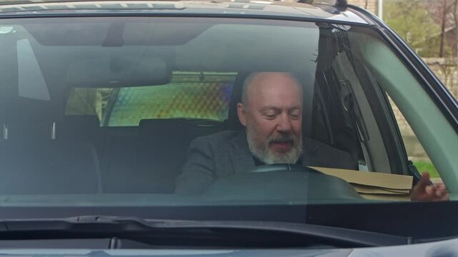Senior Man Receiving Takeout Food in Car