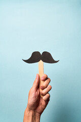 Male Hand holding mustache supporting prostate cancer awareness month and men's health