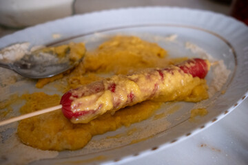 Homemade corn dog in a pan close up