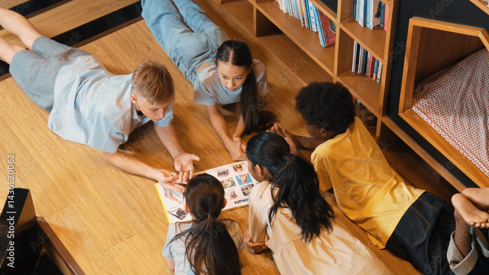 Poster group of diverse children lying down in circle while reading a book at library. top view of girl sha