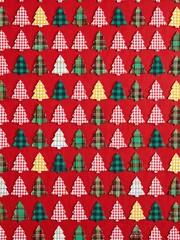 Festive patterns of red and green trees adorn a surface, evoking warmth and cheer ideal for holiday gatherings and cheerful decorations during the joyful season.