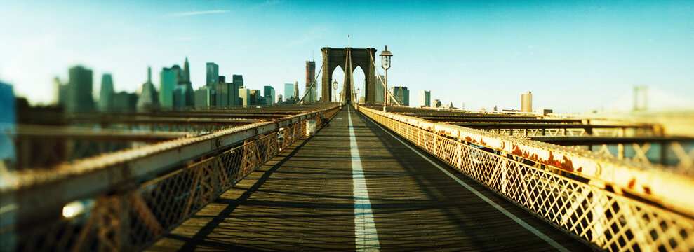 Panoramic view of suspension bridge with a city in the background, Brooklyn Bridge, Manhattan, New York City, New York State, USA.