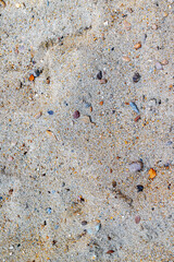 Textured sandy beach surface with mixed pebbles and grains